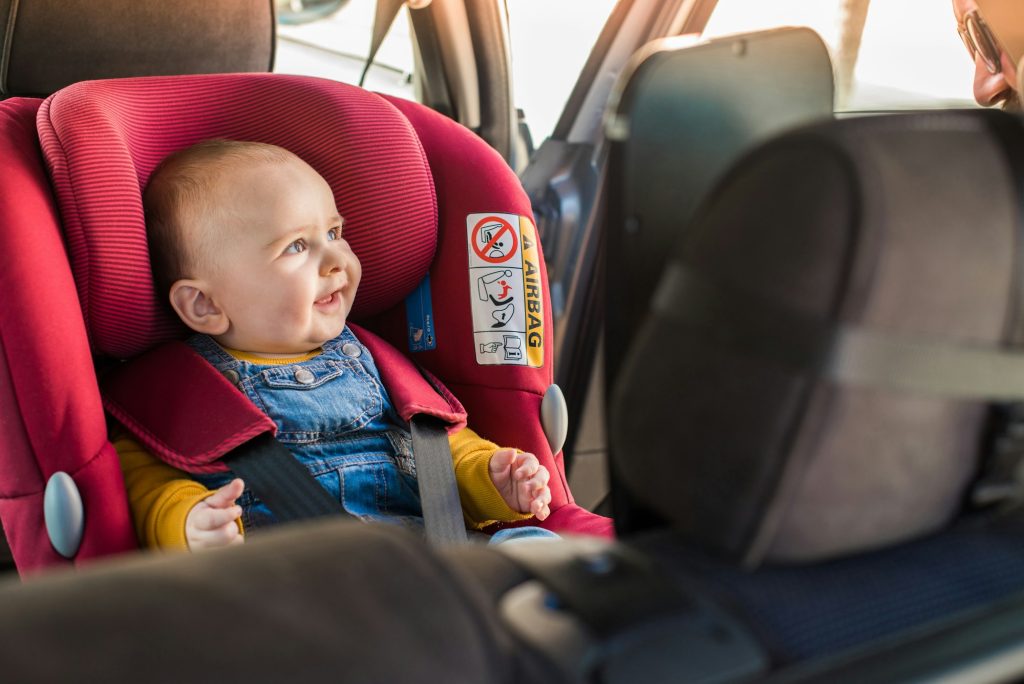 Father fasten his baby in car seat