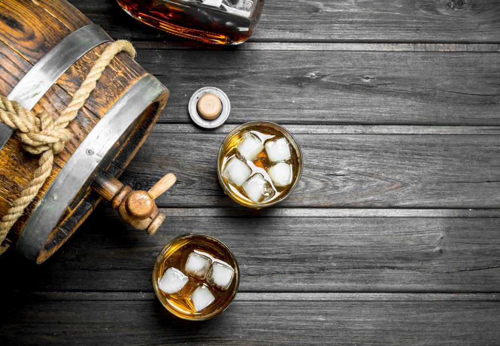 Whisky in glasses and barrel.