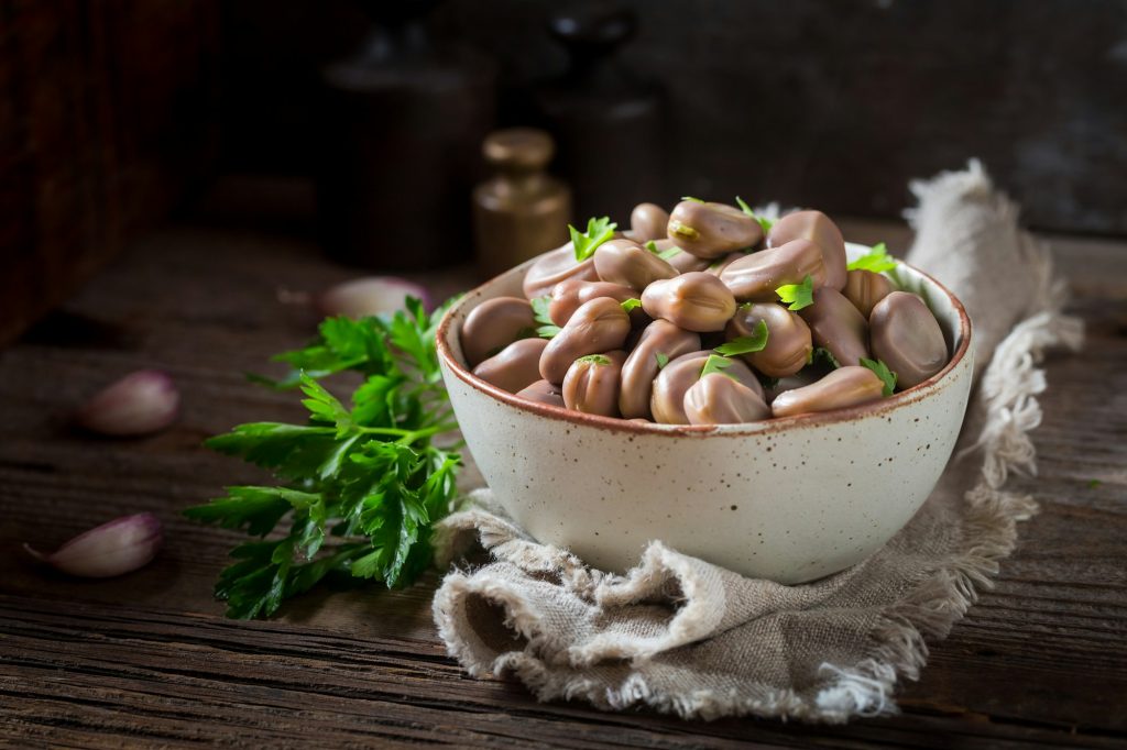 Healthy boiled broad beans with garlic and parsley.